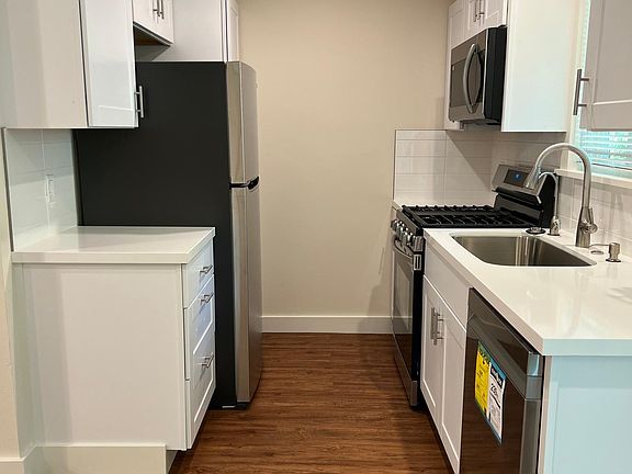 Kitchen with dishwasher, fridge, stove, microwave, and significant storage.