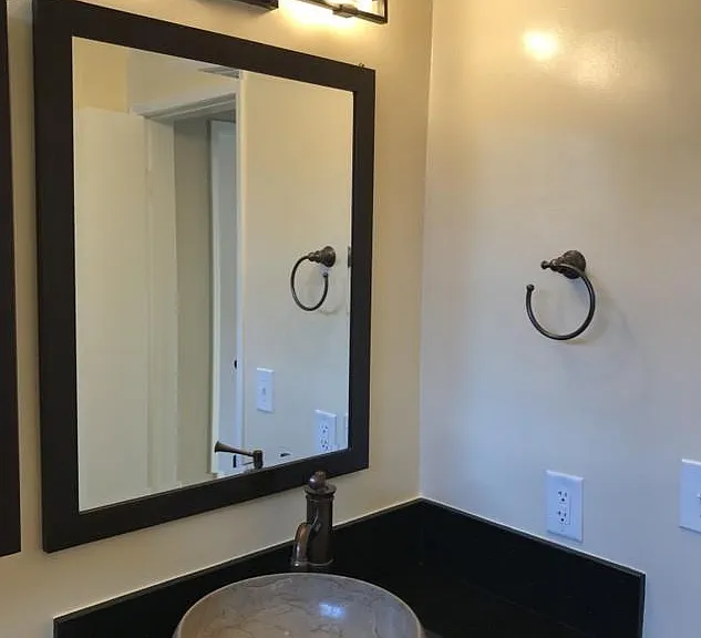 Bathroom with black marble countertop and marble sink.