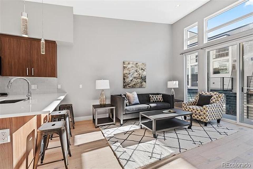 Open living/dining/kitchen with large windows that lead to balcony
