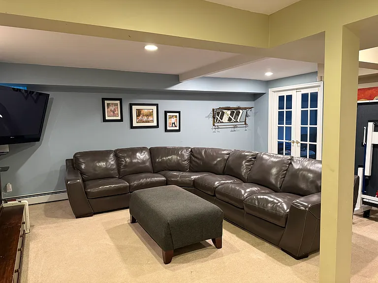 Basement living room with mudroom leading to back driveway