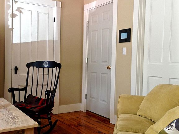 LIving room showing coat closet, front door, and door to bedroom two