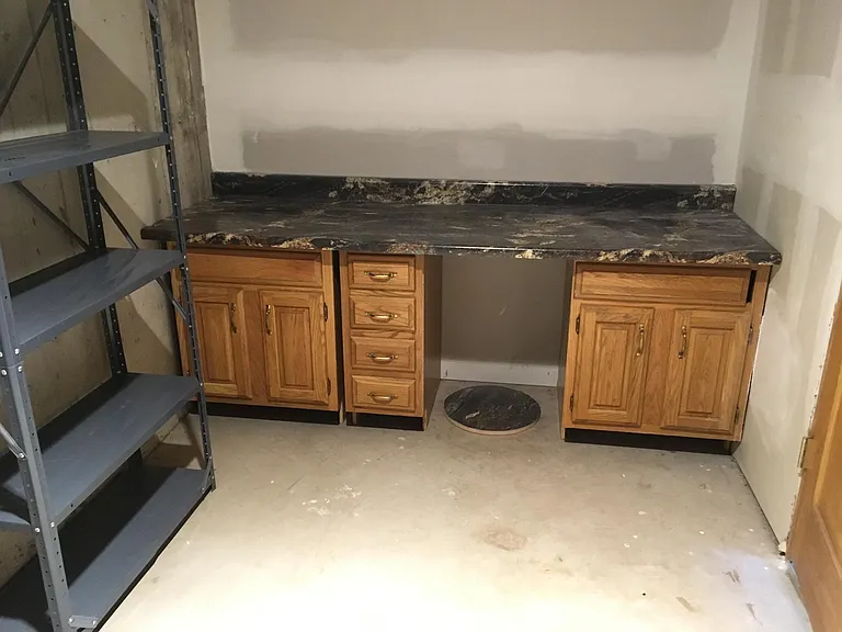 Boiler room has workspace and cabinets and small refrigerator (now shown)