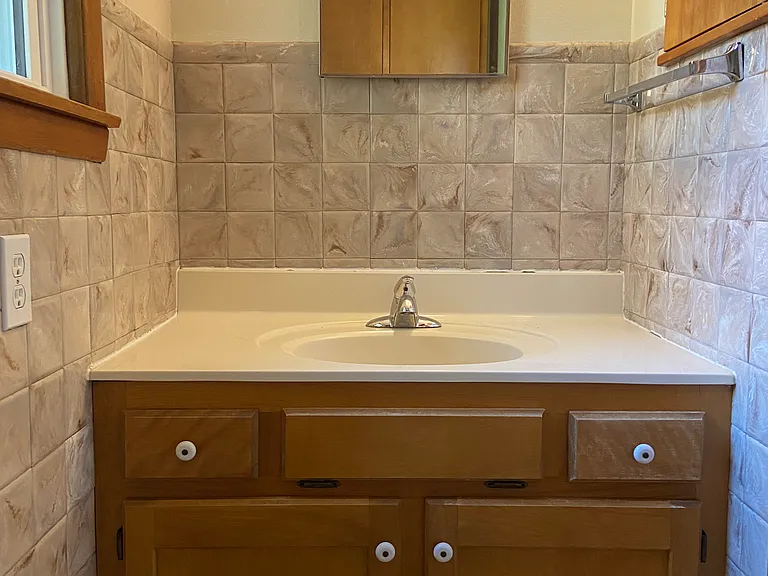Vanity area of 3/4 bath near laundry area