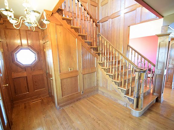 The bright foyer welcomes you with impressive woodwork, unique windows, and a grand staircase.