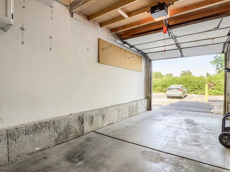 Attached Garage & Park Access _ Enjoy the convenience of a one-car attached garage with built-in cabinets and overhead storage, with Playa Del Carmen Park just steps away featuring green space and a dog park.