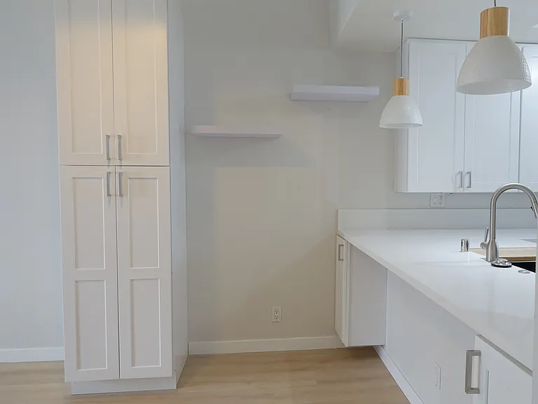 Dining area: Bar seating with pendant lights and undercounter cabinets. 
96" tall cabinet and two floating shelves