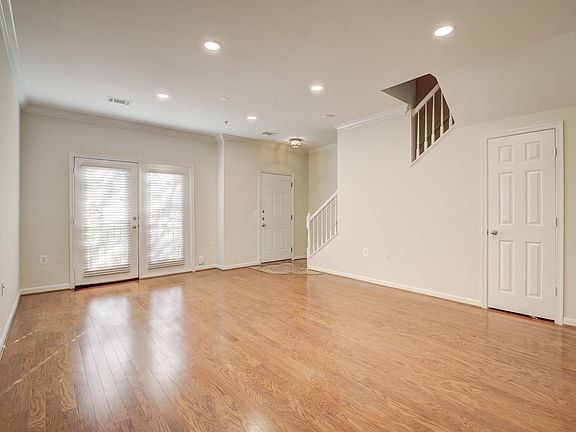 The living area with wood floors and recessed lighting on the bottom level