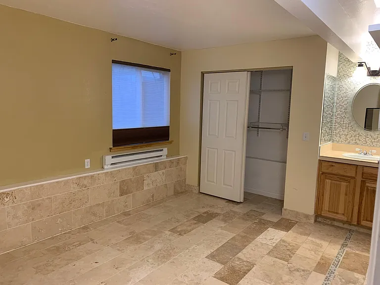 Master bedroom with custom hand-laid radiant heat tile; custom insulated window shades and closet organizer, in-room sink with custom tile counter top and mosaic back splash