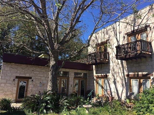 Unique stone home with 20 plus doors, many patios in shady yard