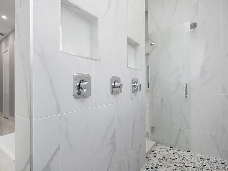 large shower with niches and 3 shower heads of which one rain showerhead