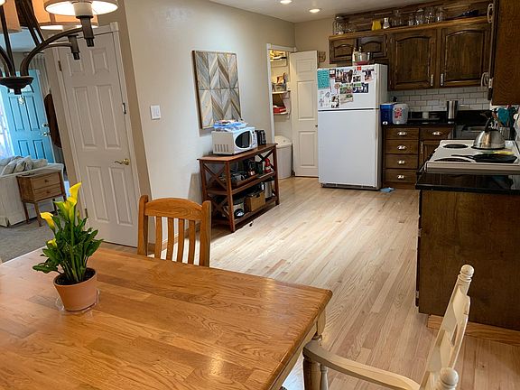 Dining area with living room to the left and bright kitchen with large pantry.