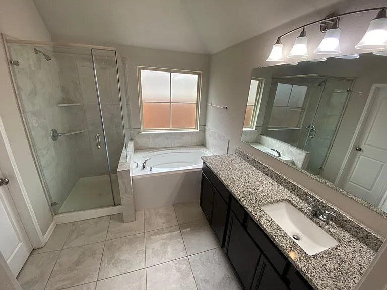 Private master bathroom with shower, bathtub, and spacious walk-in closet