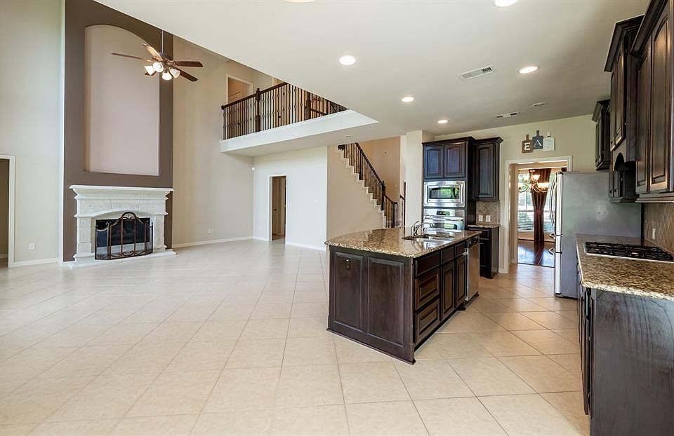 Large island kitchen with stainless appliances and gas cooktop.
