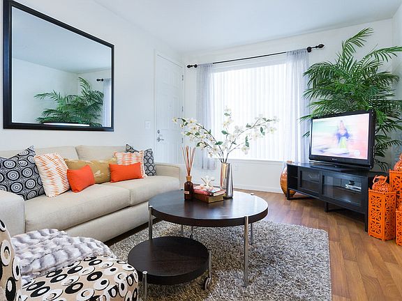 Staged living room with a large window and hardwood-style vinyl flooring.