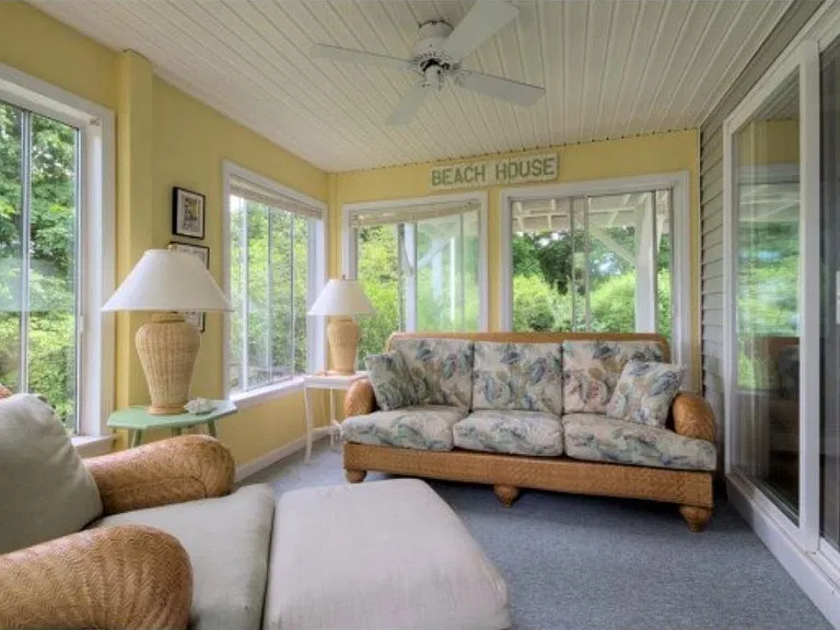 Three-season sunroom is the perfect place to enjoy your morning coffee and leads out to the private deck