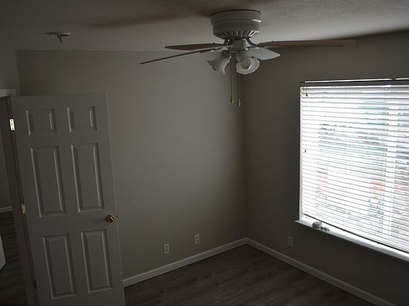 Two bedrooms the same across from the Master Bedroom with grey plank flooring and fans.