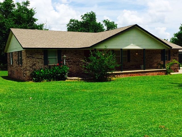 Front view of the house; the carport is attached on the right side. There are steps at either end of