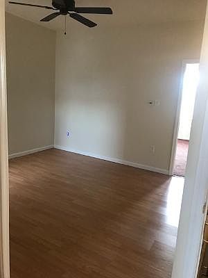 Nice size living room with hardwood floors and ceiling fan.