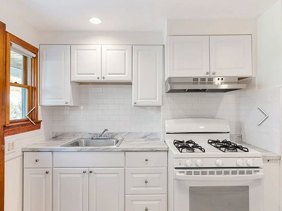 Freshly updated kitchen with ceramic tile backsplash, gas oven, fridge included