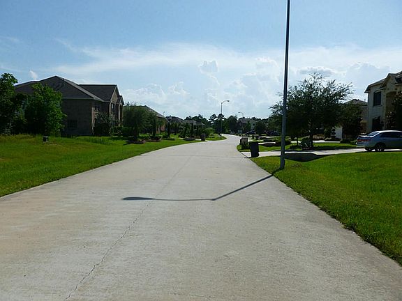 Standing in front of the lot and looking down the street.