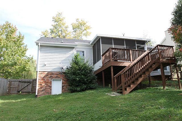 Back of house from the fenced-in backyard showing the screened in porch