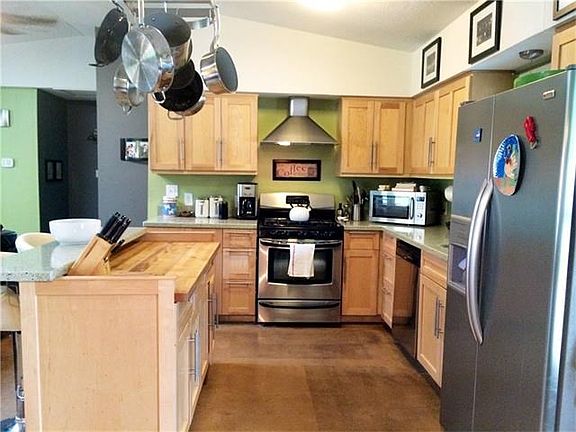 Stainless steel appliances, gas range with quartz counter tops & butcher block island for prepping meals.