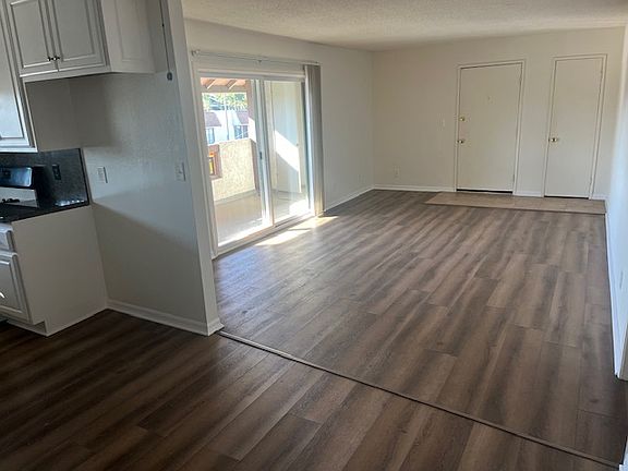 view from dining room to kitchen (left) living room and slider to balcony