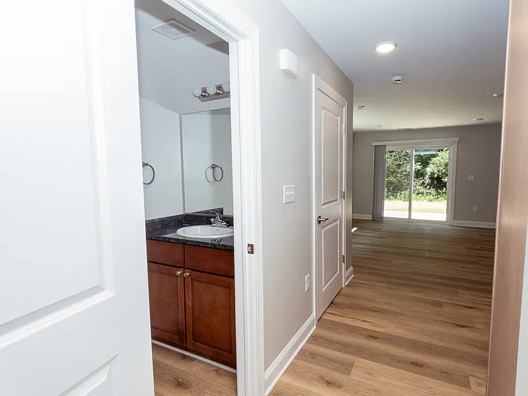 Hallway to kitchen/living room with 1/2 bath and closet pantry
