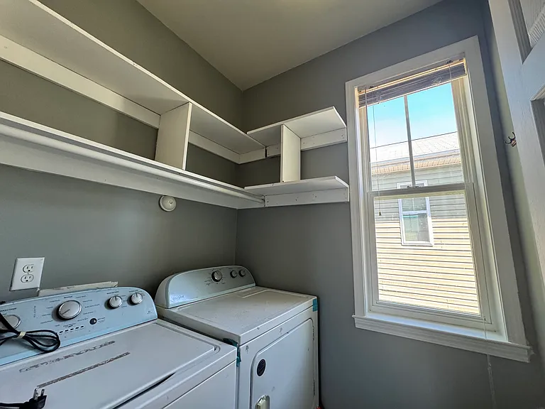 Washer and dryer included! There's also a built-in wooden shelf above for storing supplies and hanging things up.