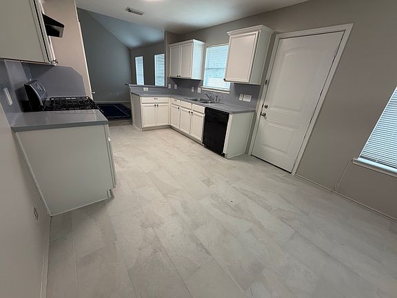 Updated 2026 kitchen with new tile floor, lighting, and neutral colors.