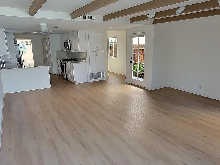 Family room with new flooring, pantry, cabinetry and tract lighting.