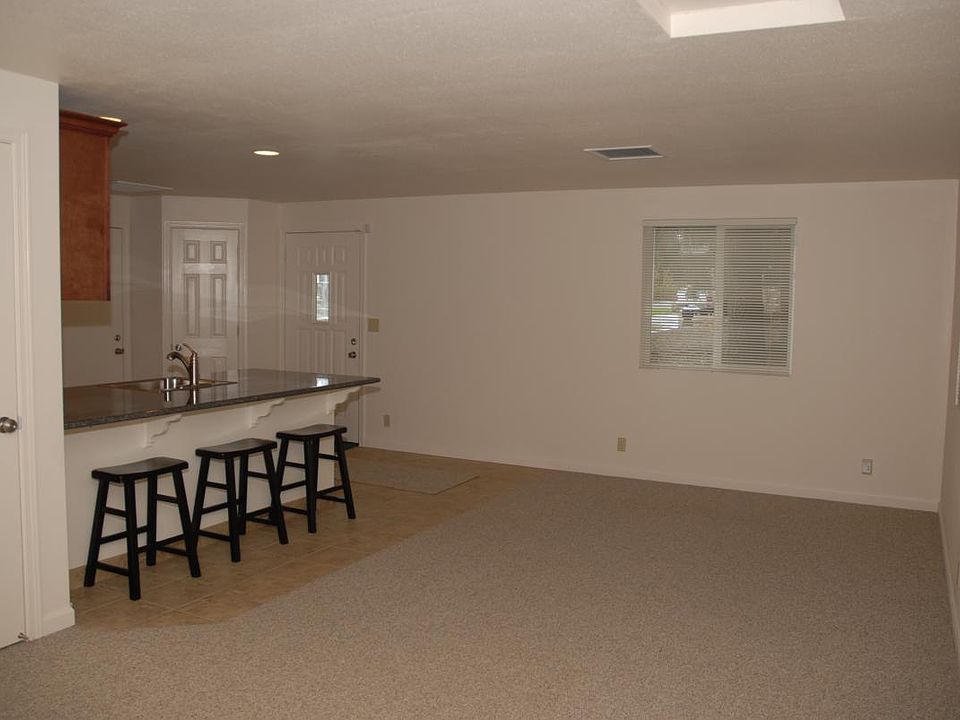 view of front door and kitchen from family room. To the left is a coat closet.