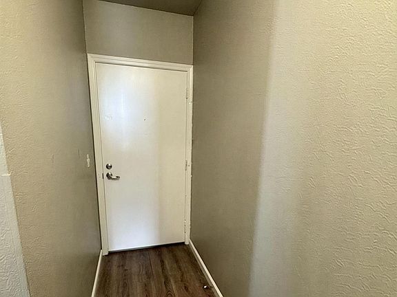 Inviting entrance with sleek wooden flooring and a minimalist white door. Inviting entrance with sleek wooden flooring and a minimalist white door.
