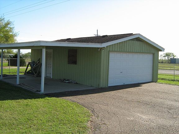 LARGE GARAGE AND CARPORT HAS STORAGE/WORKSHOP
