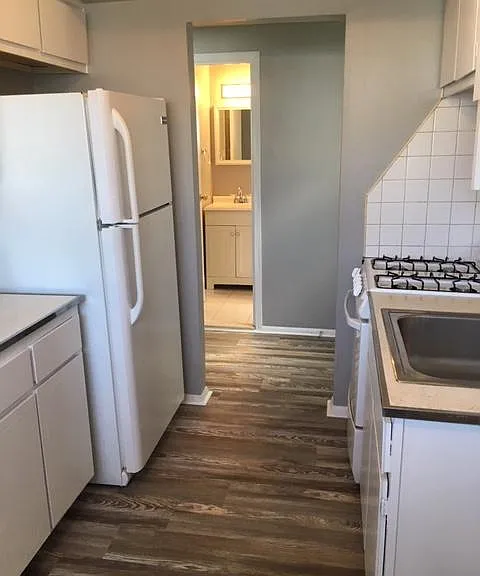 Kitchen with bathroom beyond hallway