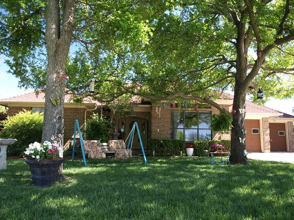 141 Runaway Bay Drive.  Lovely shade trees in the front.  Note the offset double garage to the side.
