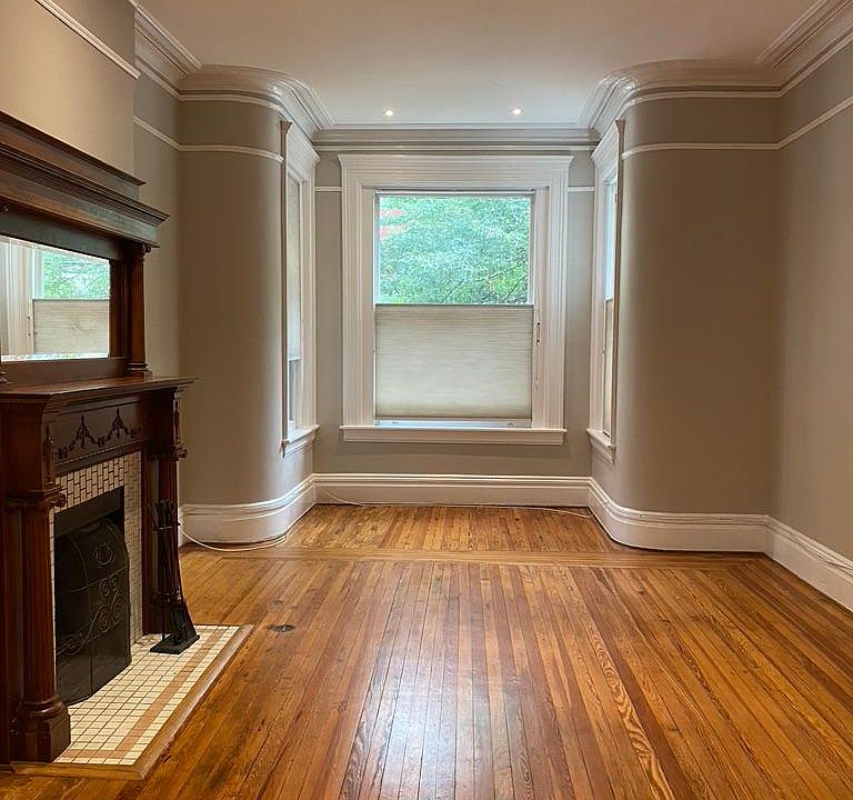 Living room with bay window overlooking P Street. Heart-of-pine floors. Original fireplace with hand-carved mantel. New recessed lights. Freshly painted.