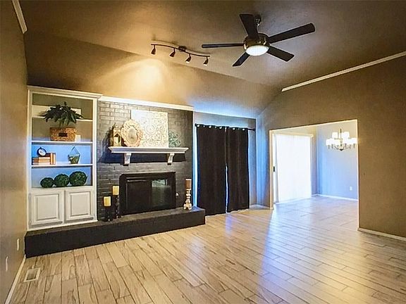 Stunning spacious living area with wood tile flooring, built-in bookcase, gas fireplace.