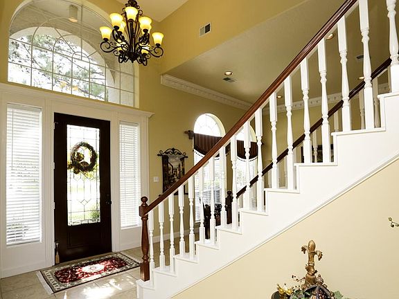View of the beautiful leaded glass front door and window. Notice the moldings in the front formal.