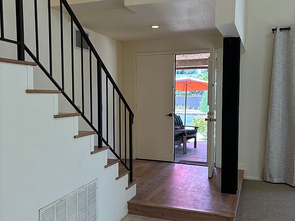 Front door from inside house and view of stairs