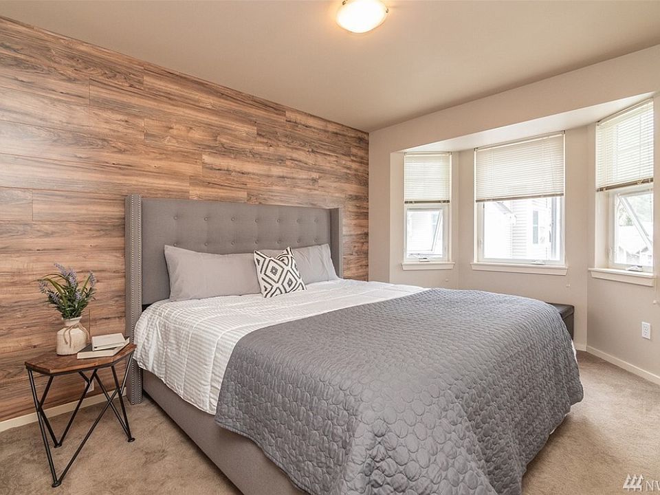 (Primary Bedroom): Spacious primary suite highlighted by a stunning rustic wood-accent wall. (Bed not included)