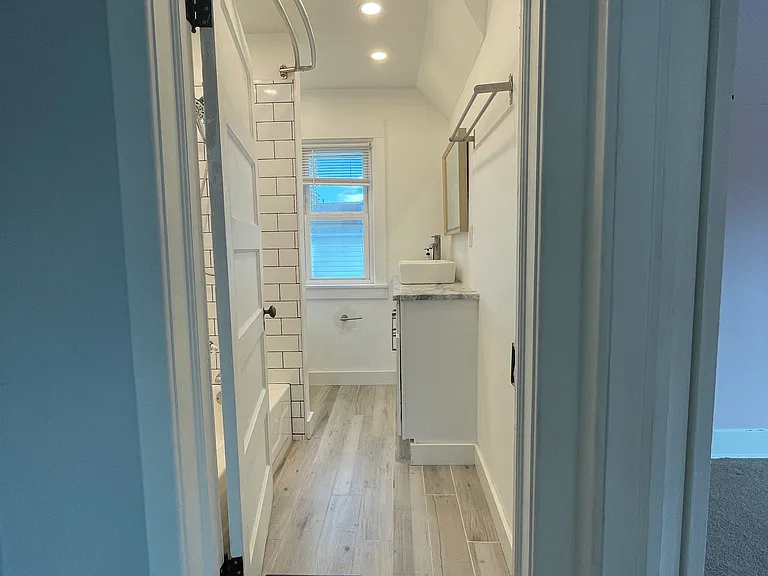 Updated full bathroom with a modern vanity, vessel sink, stylish mirror, and clean contemporary finishes.