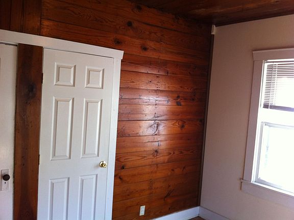 Front bedroom, some parts of house have original wood walls.