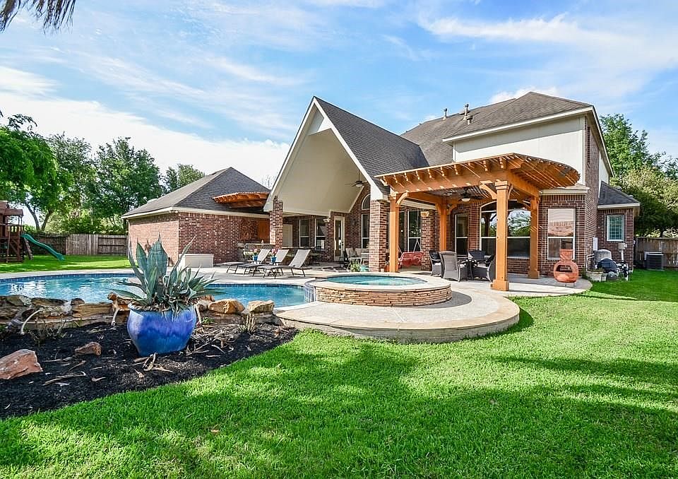 Beautiful backyard oasis. Pool has a rock water fall and a covered kitchen with TV connections already installed.