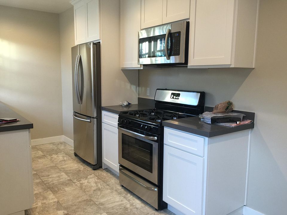 Kitchen with custom cabinetry, granite countertops, new stainless steel appliances: stove, oven, microwave, refrigerator, dishwasher and disposal.