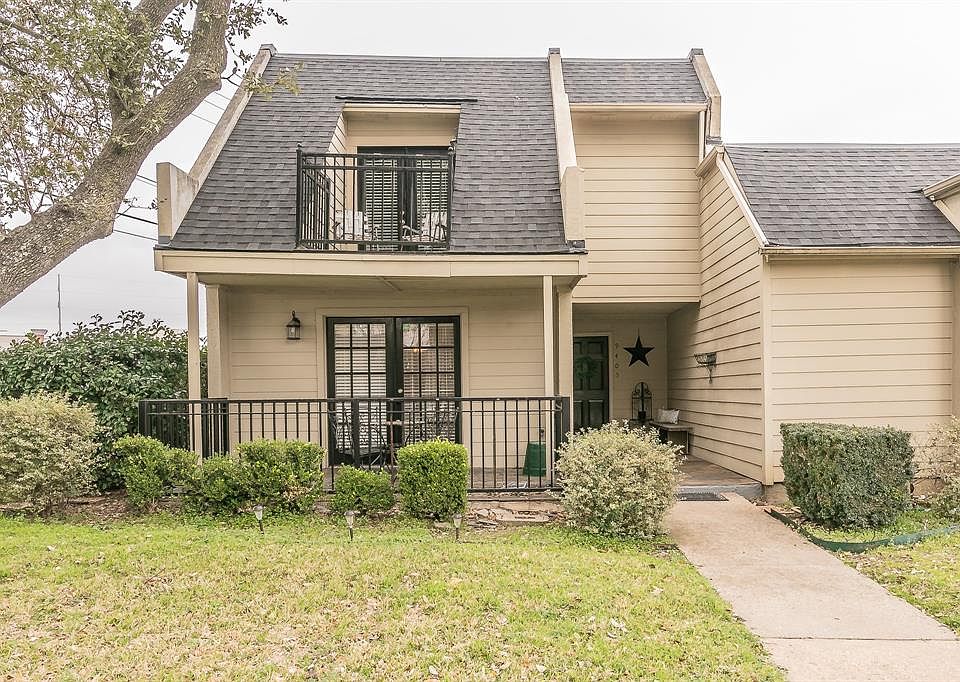 Welcome home! View of Townhome front featuring corner lot, front yard, two balconies, covered porch with a beautiful open entryway