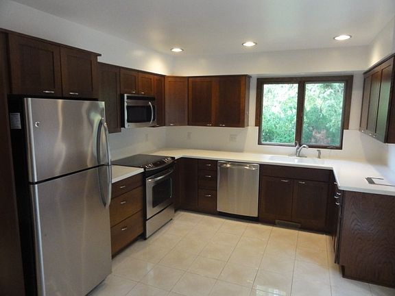 New kitchen cabinets, crisp white ceramic tile floors and co