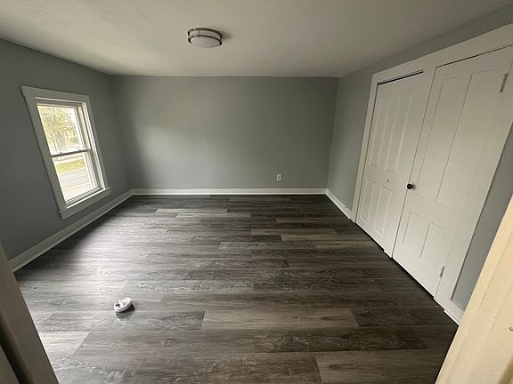 Primary bedroom with abundant natural light, neutral tones, and new luxury vinyl flooring.