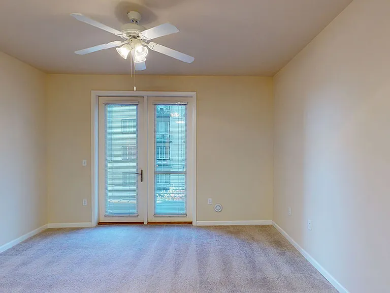 Apartment living room with plush carpet flooring.