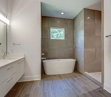 Master suite bathroom with soaking tub and shower with floor-to-ceiling tiles in those areas